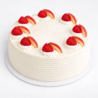 Ice Wind cake with whipped cream, raspberries and peach slices
